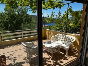 a patio with a table and chairs on a balcony at Apartman Perić in Bigova