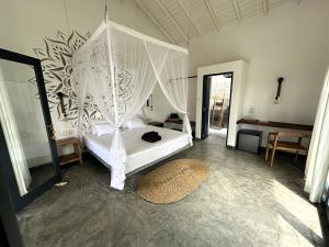 阿漢伽馬的住宿－Ebony Boutique Villa，一间卧室配有一张带天蓬的白色床