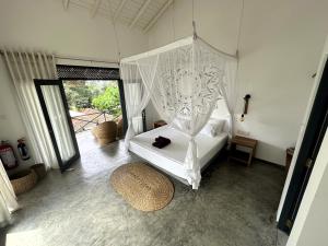 um quarto com uma cama de dossel branca em Ebony Boutique Villa em Ahangama