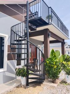 a spiral staircase on the side of a house with plants at Villa Adeeva Homestay Langkawi in Pantai Cenang