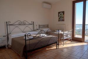 モンテグラナーロにあるVilla Fortuna Belvedereのベッドルーム1室(ベッド2台付)、バルコニーが備わります。