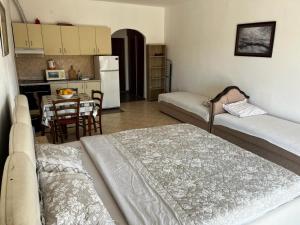 a living room with two beds and a kitchen with a table at Apartman Perić in Bigova