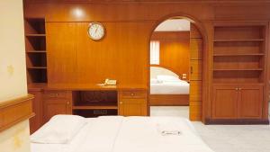 a bedroom with a bed and a clock on the wall at The Kaze 34 Hotel and Serviced Residence in Bangkok