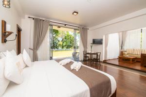 Grand Argyle Resort في هاتون: غرفة نوم بسرير ابيض كبير وغرفة معيشة