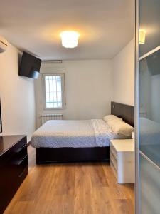 1 dormitorio con cama y espejo en Alojamiento turístico en Madrid en Madrid
