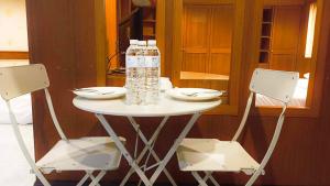 a table with a bottle of water and two chairs at The Kaze 34 Hotel and Serviced Residence in Bangkok