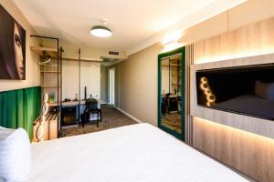a hotel room with a bed and a mirror at Business Hotel Conference Center & Spa in Târgu-Mureş