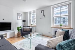 a living room with two couches and a television at 2BR in Soho - Charlotte Street - CityApartmentStay in London