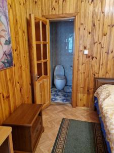 ein Schlafzimmer mit einem WC in einem Zimmer mit Holzwänden in der Unterkunft Nautilus in Odessa