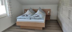 una camera da letto con un letto con quattro cuscini sopra di Illerblick a Blaichach
