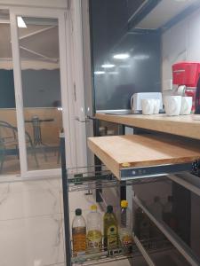 a kitchen with an open shelf with bottles in it at 100sqm comfort free parking Airport 10min in Thessaloniki