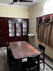 jadalnia z drewnianym stołem i krzesłami w obiekcie The Padmavathi Guest House - Vizag w mieście Visakhapatnam