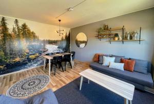 a living room with a blue couch and a table at Pine Sky Apartments in Ivalo