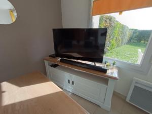 een flatscreen-tv zittend op een kast bij Au cœur de la baie de canche entre terre et mer in Étaples