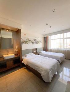 Cette chambre comprend deux lits et une télévision. dans l'établissement Biling Hotel, à Fangshan