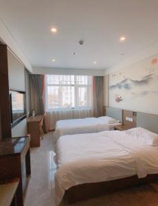 una camera d'albergo con tre letti e una televisione di Biling Hotel a Fangshan