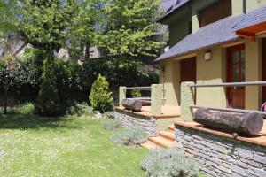 a house with a garden with a stone wall and a yard at LUDERNA - Apartamento Espiargo in Garós
