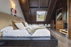 Un dormitorio con una cama grande en una habitación con techos de madera. en Luderna - Casa con terraza Unhola, en Bagergue