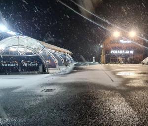 un estacionamiento en la nieve por la noche en Vb apartmani en Prijedor