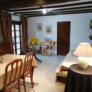 uma sala de jantar e sala de estar com mesa e cadeiras em Gîte Rozies Dunes 6 p em Dunes