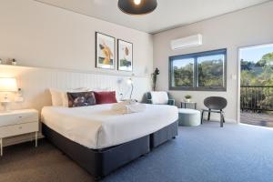 a bedroom with a large white bed and a balcony at Victoria Hotel Toodyay in Toodyay