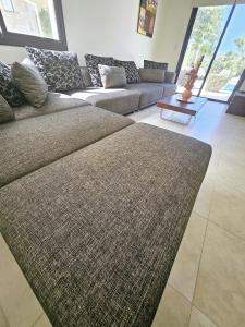ein Wohnzimmer mit einem Sofa und einem Tisch in der Unterkunft Modern 3 bedroom villa, pool and close to golf course in Paphos City