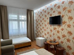 a bedroom with a bed and a tv on the wall at Dany Holiday in Eforie Nord