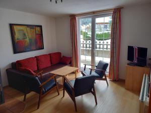 a living room with a couch and a table and chairs at Haus Aineckblick, Liftstrasse 250, Top 3 in Sankt Margarethen im Lungau