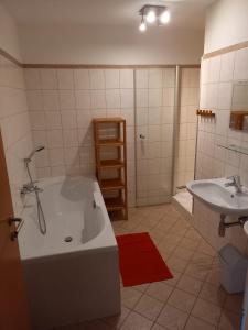 a bathroom with a bath tub and a sink at Haus Aineckblick, Liftstrasse 250, Top 3 in Sankt Margarethen im Lungau +4 photos