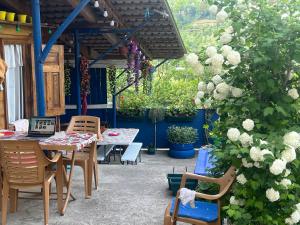 a patio with a table and chairs and flowers at Garden house in Ambrolauri