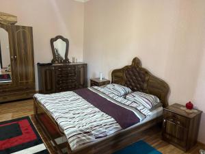 a bedroom with a bed and a dresser and a mirror at Garden house in Ambrolauri