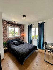 a bedroom with a bed and a brick wall at Maison spacieuse proche Paris in Bonneuil-sur-Marne +24 photos