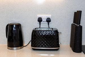 einen Toaster und einen Mixer auf der Theke in der Unterkunft Stylish Apartment w/ Private Garden - Dog Friendly in Newport