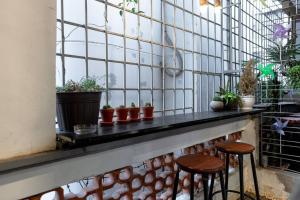 a window with two stools and potted plants at 2 Bedroom Industrial Apartment in Central Saigon in Ho Chi Minh City