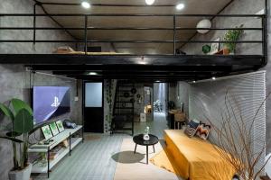 a loft room with a bed and a tv at 2 Bedroom Industrial Apartment in Central Saigon in Ho Chi Minh City