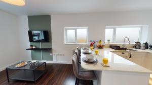 a kitchen with a table with chairs and a counter top at Stylish Duplex Apartment with Home Office in Newport