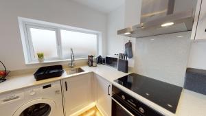 a kitchen with a washing machine and a sink at Stylish Duplex Apartment with Home Office in Newport