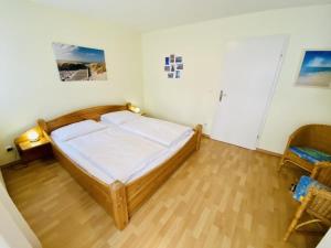 um pequeno quarto com uma cama e uma cadeira em Villa Diana/Windrose em Warnemünde