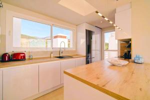 a kitchen with a counter and a large window at Luxury Penthouse Alcazaba Lagoon 521 EHHouse in Estepona