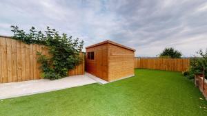 un pequeño cobertizo de madera en un césped junto a una valla en Stylish Studio Apartment with Peloton en Newport