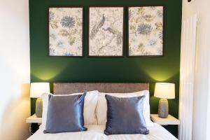 a bedroom with green walls and a bed with blue pillows at Studio Apartment with 65" Smart TV in Newport