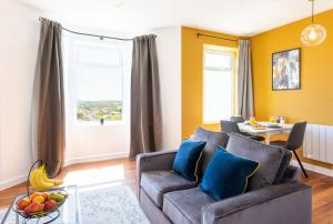 a living room with a couch and a table at Studio Apartment with 65" Smart TV in Newport