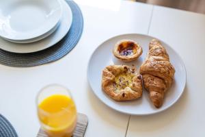 a plate with pastries and orange juice on a table at Studio Apartment with 65" Smart TV in Newport