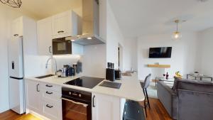a kitchen with white cabinets and a counter top at Studio Apartment with 65" Smart TV in Newport
