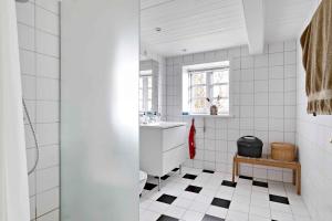 Baño blanco con suelo de baldosa blanco y negro en Cozy And Functional House By The Baltic Sea en Stege