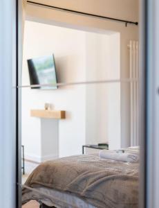 a mirror reflection of a bed in a bedroom at Studio Apartment with 65" Smart TV in Newport
