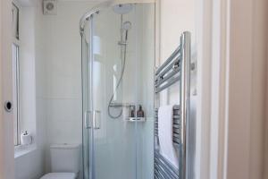 y baño con ducha de cristal y aseo. en Studio Apartment with 65" Smart TV en Newport