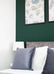 a bedroom with green walls and a bed with pillows at Studio Apartment with 65" Smart TV in Newport