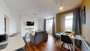 a living room with a couch and a table with chairs at Studio Apartment with 65" Smart TV in Newport +37 photos