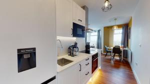 a kitchen with white cabinets and a dining room at Studio Apartment with 65" Smart TV in Newport
